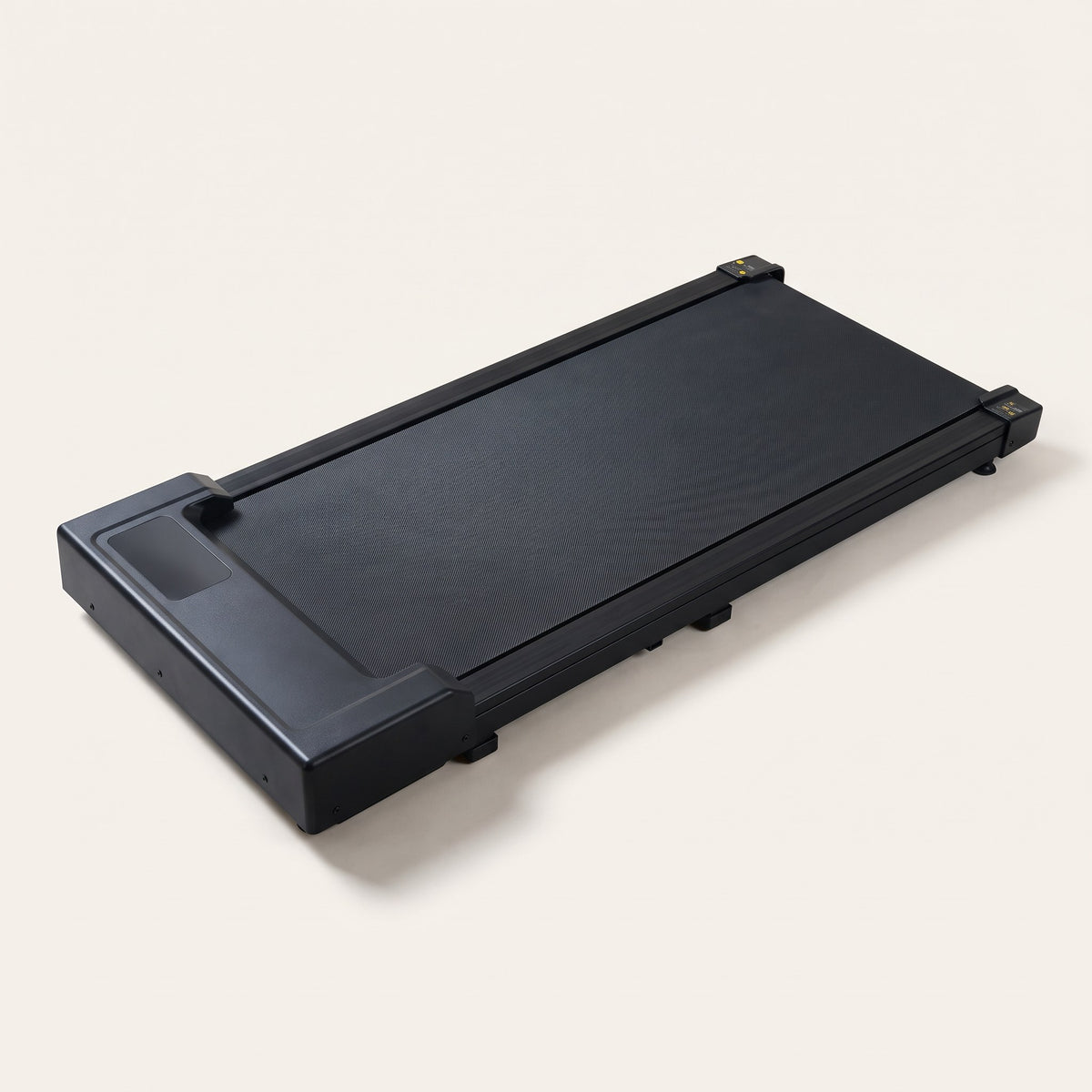 The Saunterly Walking Pad: a flat, matte black walking pad with a low motor housing at the front, three-quarter view